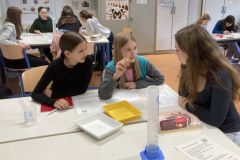 Schuelerinnen-mit-einer-ihrer-Patinnen-an-einer-Lernstation-zu-Hygieneprodukten-Foto-S.-Franken